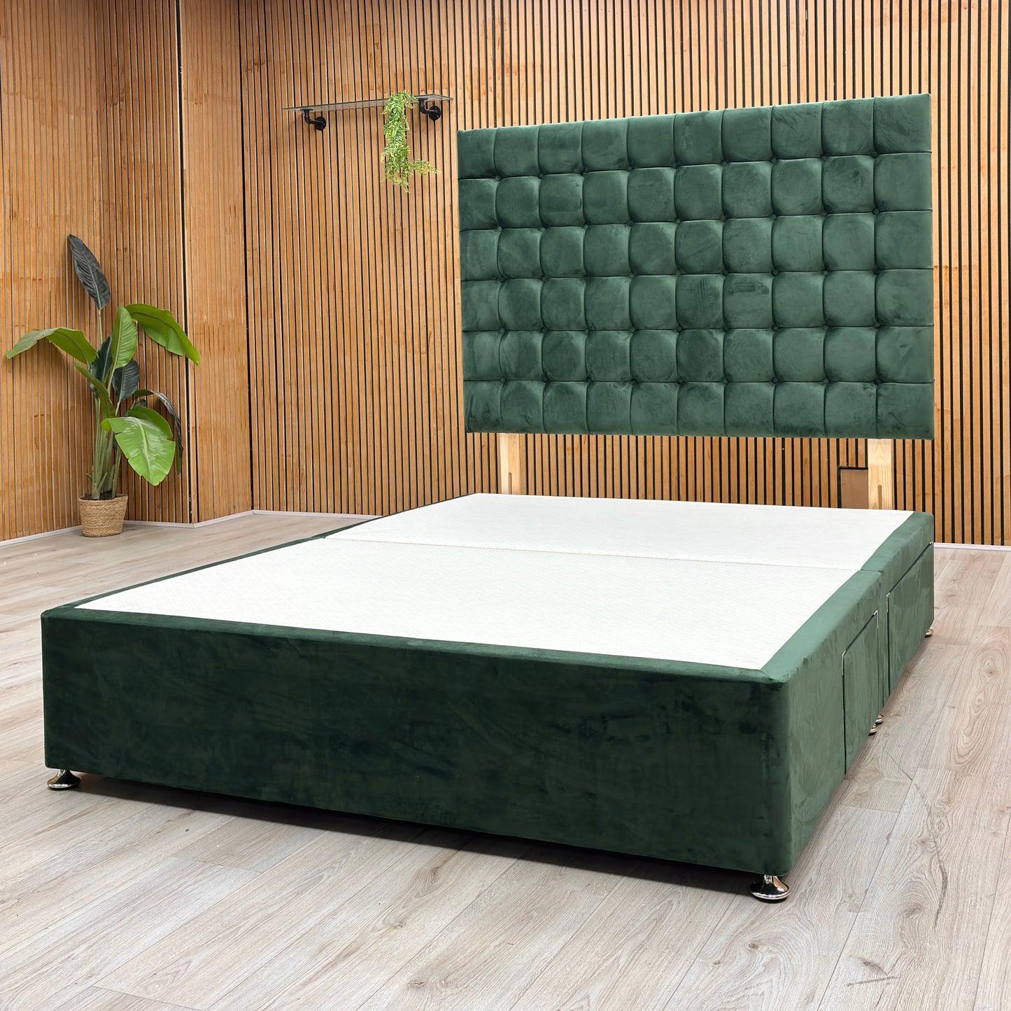 Lifestyle View Furniture Village ‘Dice’ king-size divan bed frame, showcasing a plush emerald green velvet headboard and a matching upholstered 4-drawer divan base.