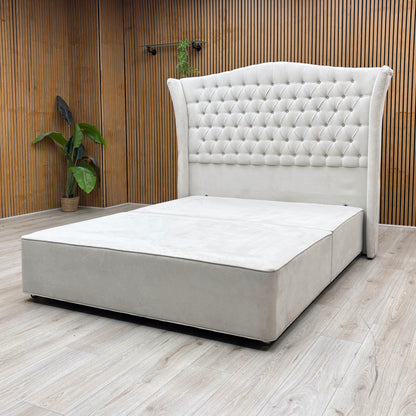 Lifestyle Shot Furniture Village Hypnos ‘Hambleden’ king-size divan bed ensemble, featuring a tall, winged floor-standing headboard and bespoke divan base upholstered in rich Imperio 903 stone grey fabric.