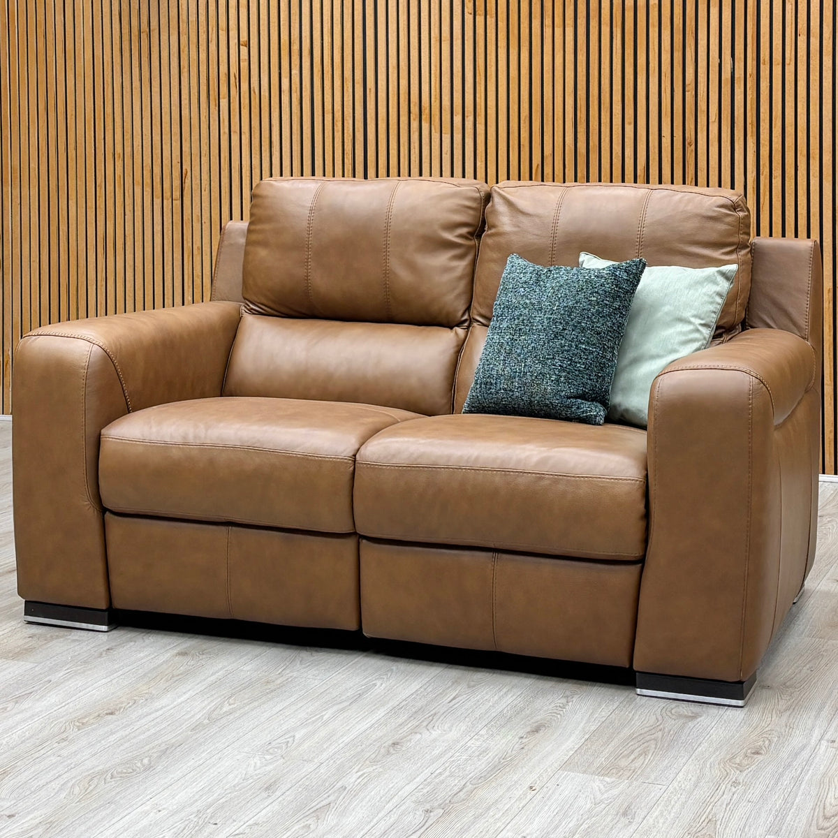 The Marinelli Viali bark brown leather 2 seater sofa from the set against a slatted wooden wall on a pale wood floor