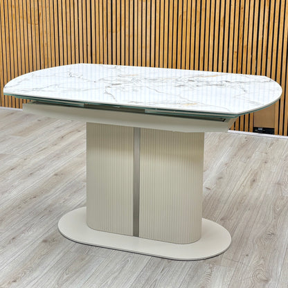 Avorio ceramic top swivel extending dining table closed, against a slatted wooden wall on a light oak floor