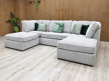 Lifestyle view the Emilia Silver sofa, illustrating the expansive "U" layout and the ample room for multi-person seating in a modern living room setting.