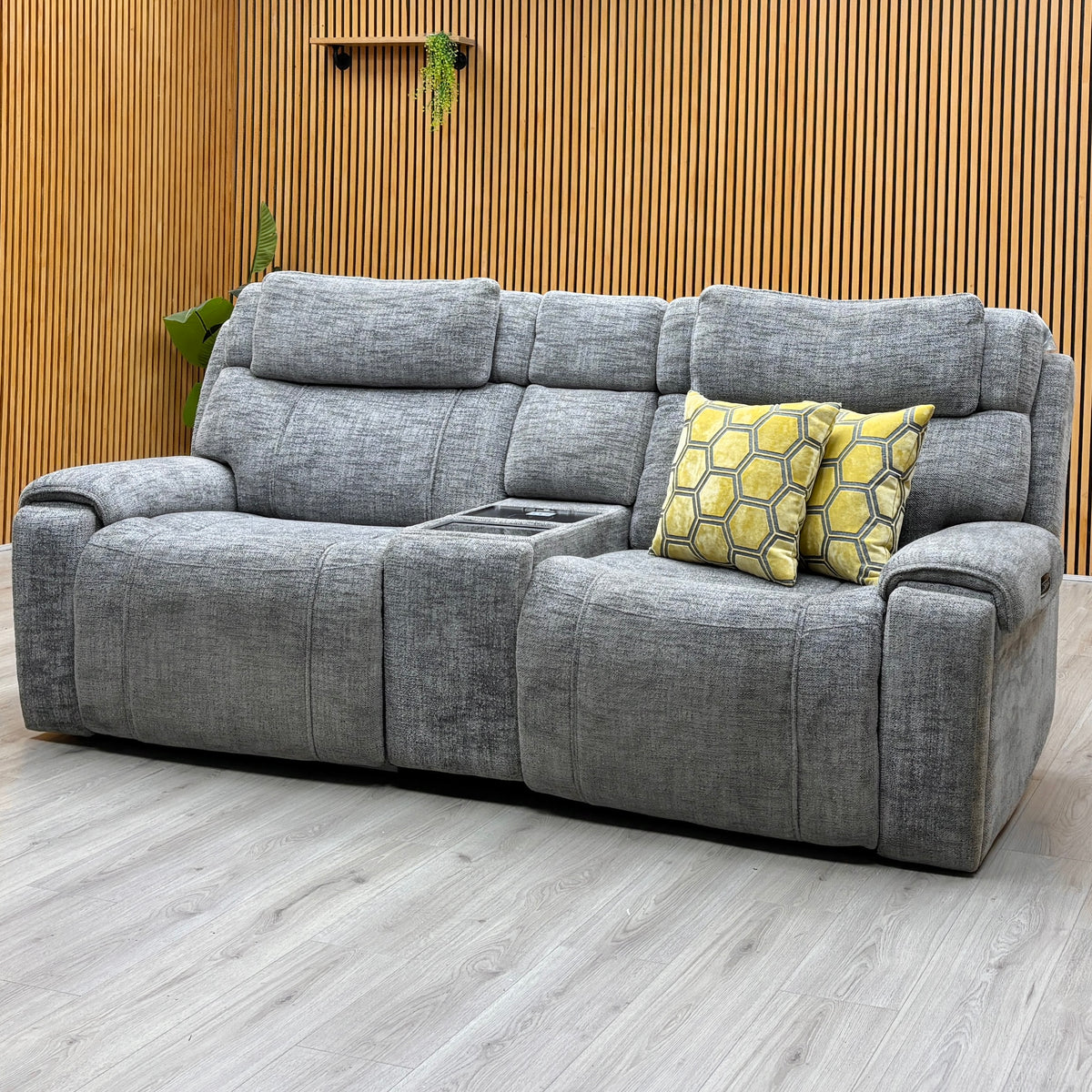 Hollywood dove grey fabric 3 seater media sofa against a slatted wooden wall on a light oak floor