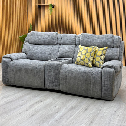Hollywood dove grey fabric 3 seater media sofa against a slatted wooden wall on a light oak floor
