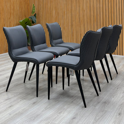 Clio grey faux leather dining chairs, set of six, against a slatted wooden wall on a light floor