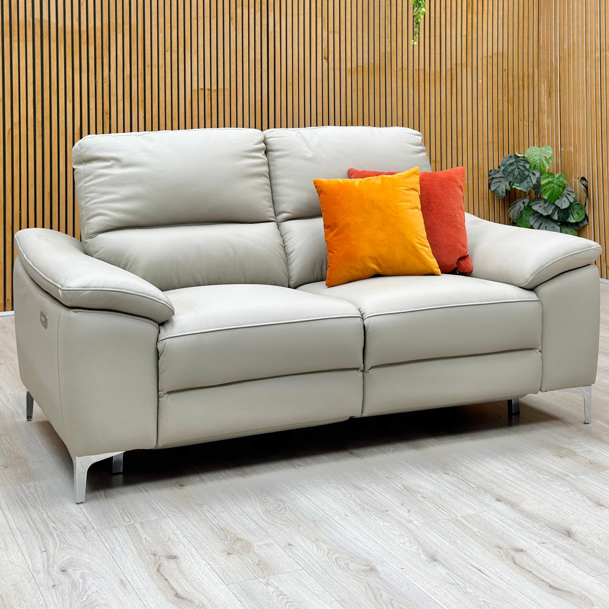 Pavilion soft grey leather 2 seater power recliner sofa upright against a slatted wooden wall