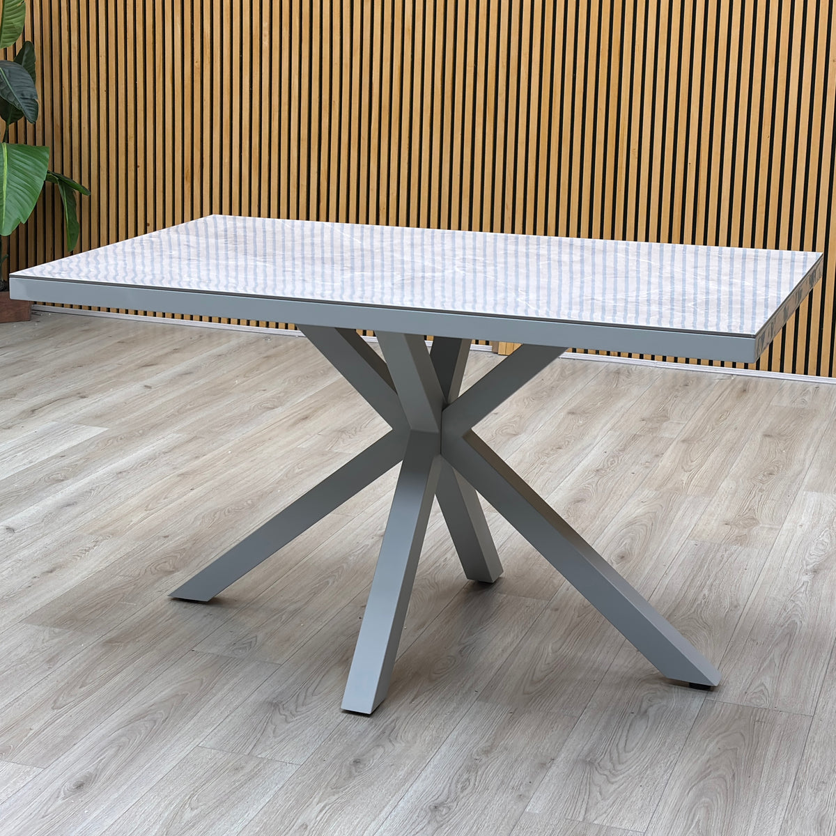Fumo high gloss grey dining table against a slatted wooden wall on a light floor