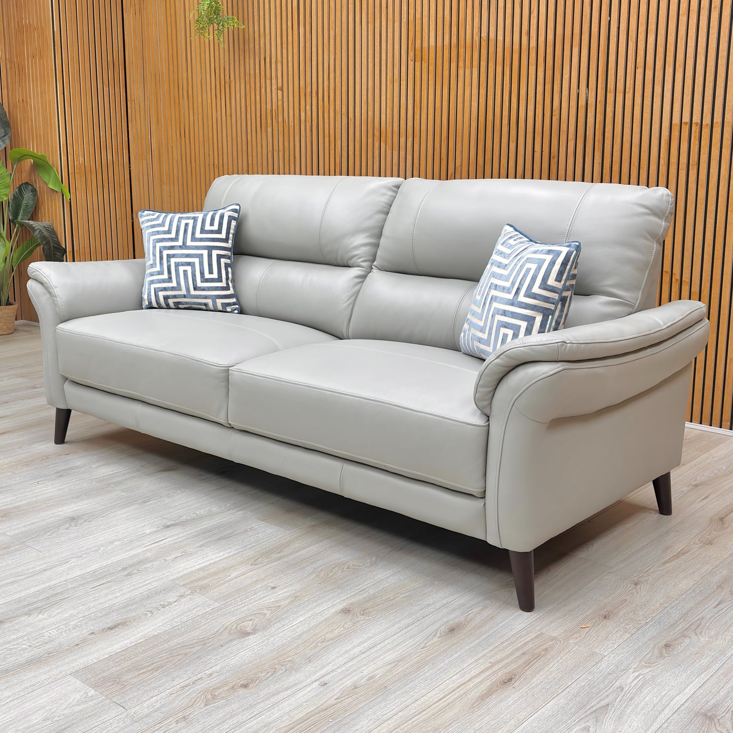 Lifestyle shot of the ‘Winner’ light grey leather sofa in a modern living room setting, highlighting its versatile and neutral color.