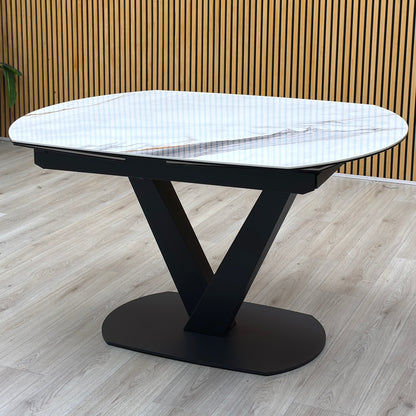 Julio Fiorentino marble ceramic extending dining table on a black V base against a slatted wooden wall