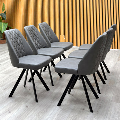 Set of 6 Jupiter grey faux leather swivel dining chairs against a slatted wooden wall on a pale floor