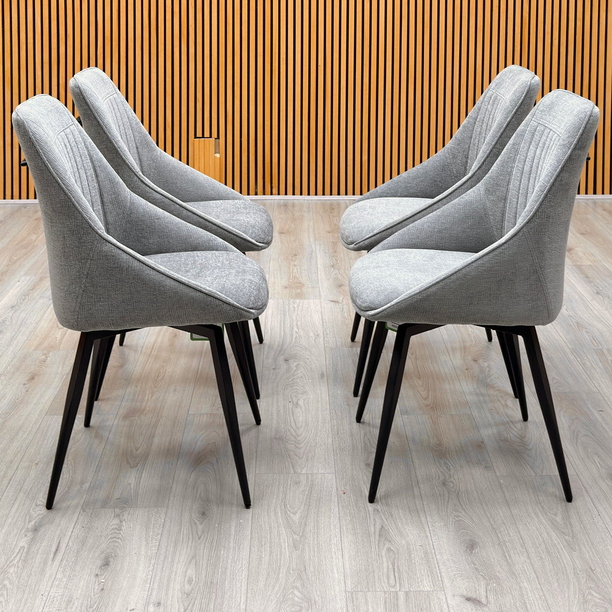 Crete light grey fabric set of 4 dining chairs against a slatted wooden wall on a light oak floor