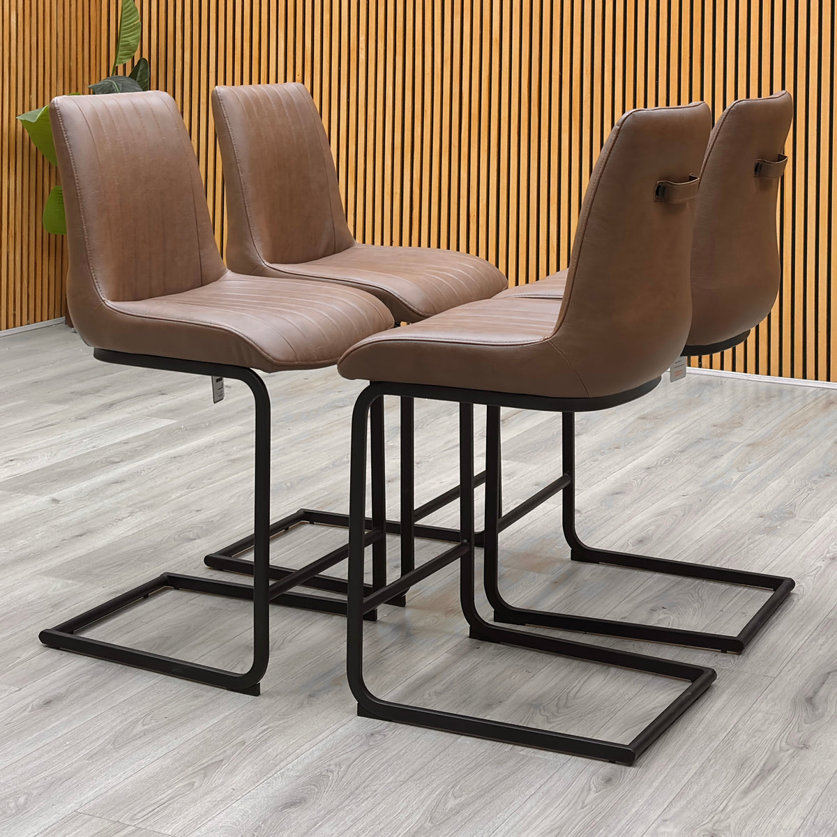 Bodahl Terra cognac brown faux leather cantilever bar stools against a slatted wooden wall