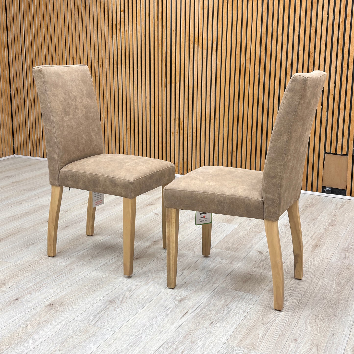 Lifestyle view of the ‘Augusta’ dining chair, emphasizing the comfortable deeply padded seat cushion and the elegant contrast between the warm taupe upholstery and dark legs.