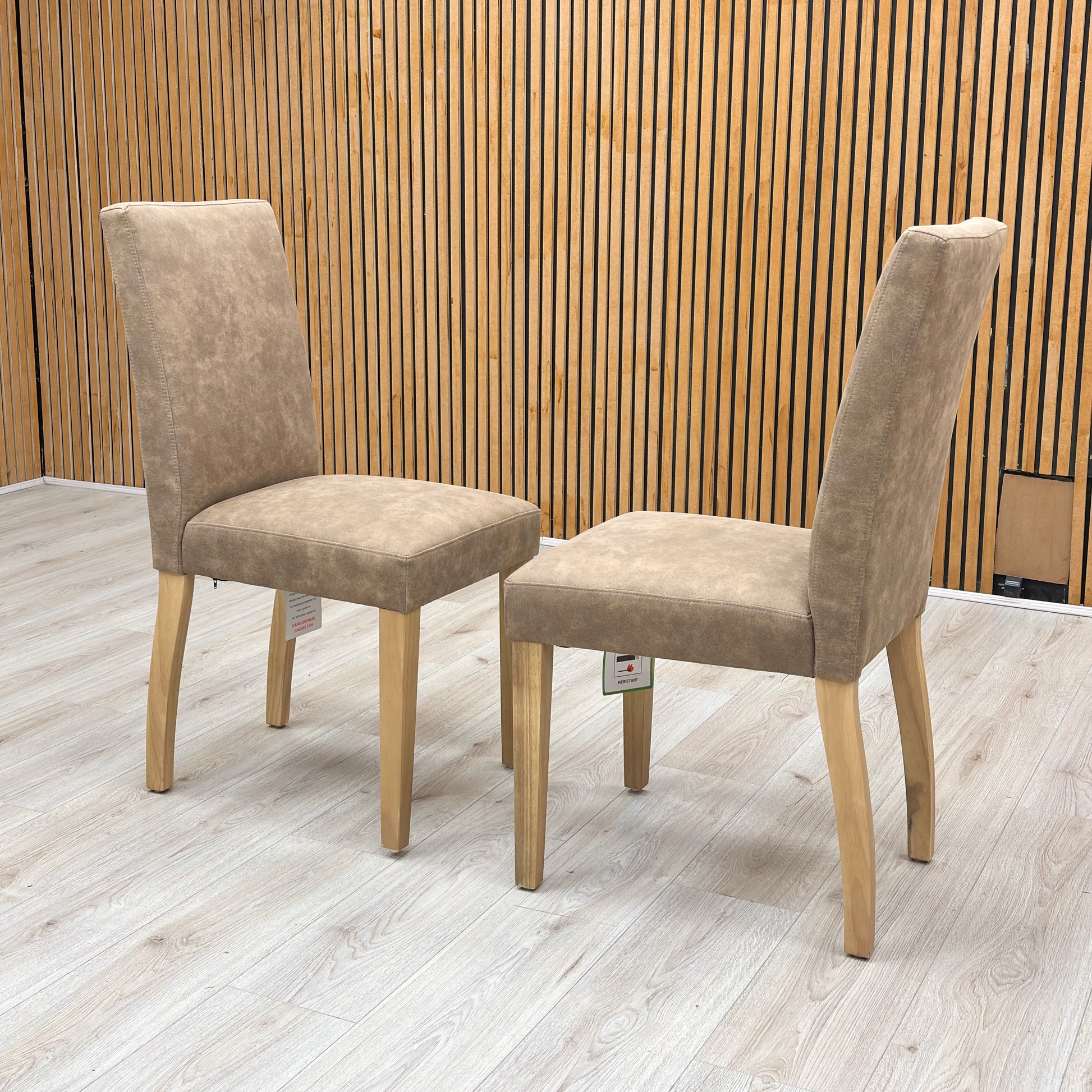 Lifestyle view of the ‘Augusta’ dining chair, emphasizing the comfortable deeply padded seat cushion and the elegant contrast between the warm taupe upholstery and dark legs.