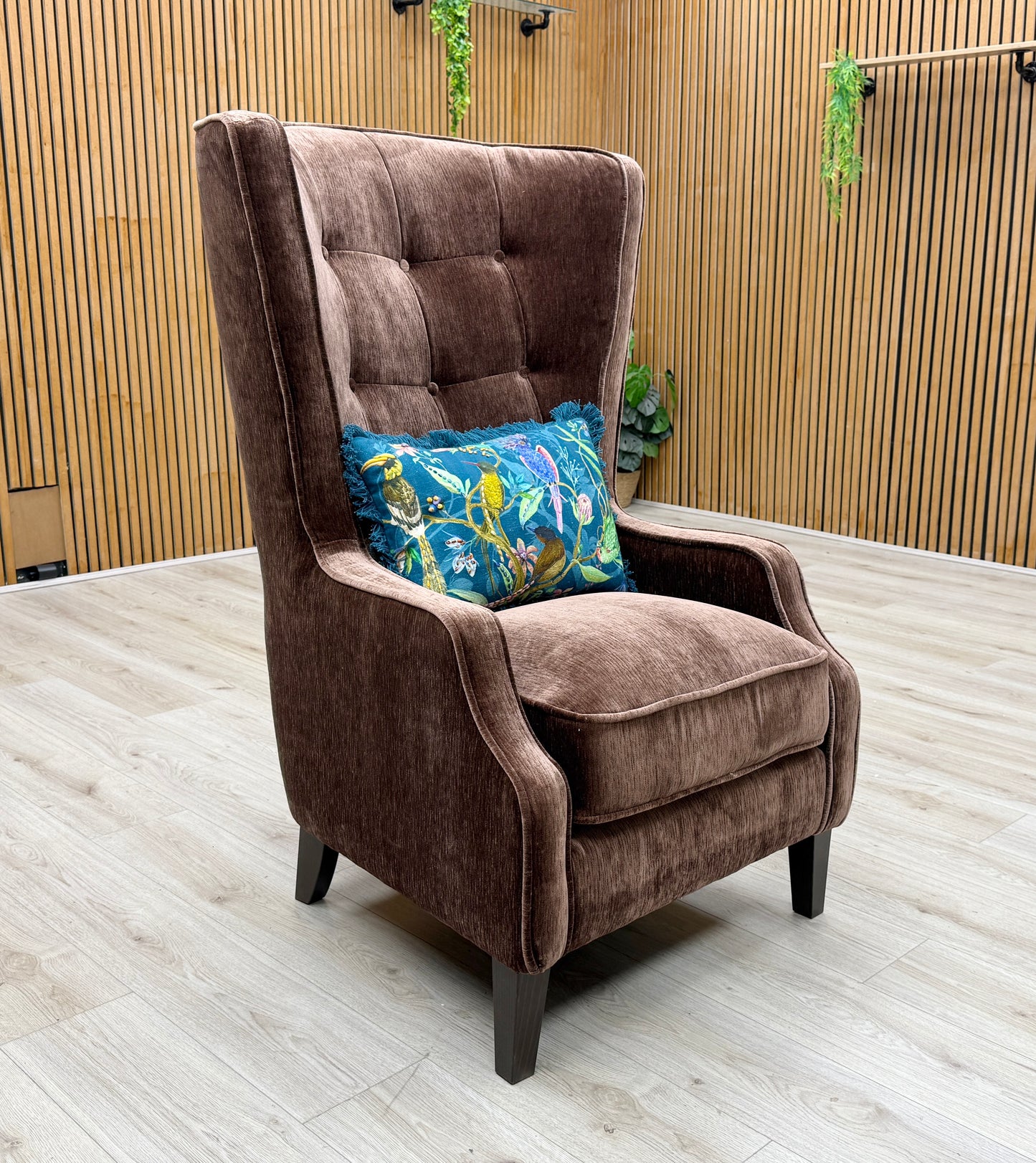 Lifestyle view of the ‘Garland’ accent chair in California Brown fabric, emphasizing its deep, welcoming seat and sophisticated modern Art Deco style.