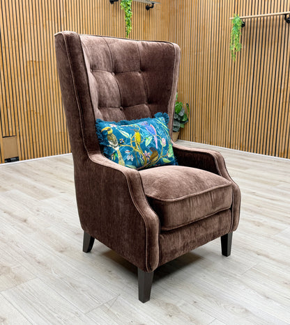Lifestyle view of the ‘Garland’ accent chair in California Brown fabric, emphasizing its deep, welcoming seat and sophisticated modern Art Deco style.