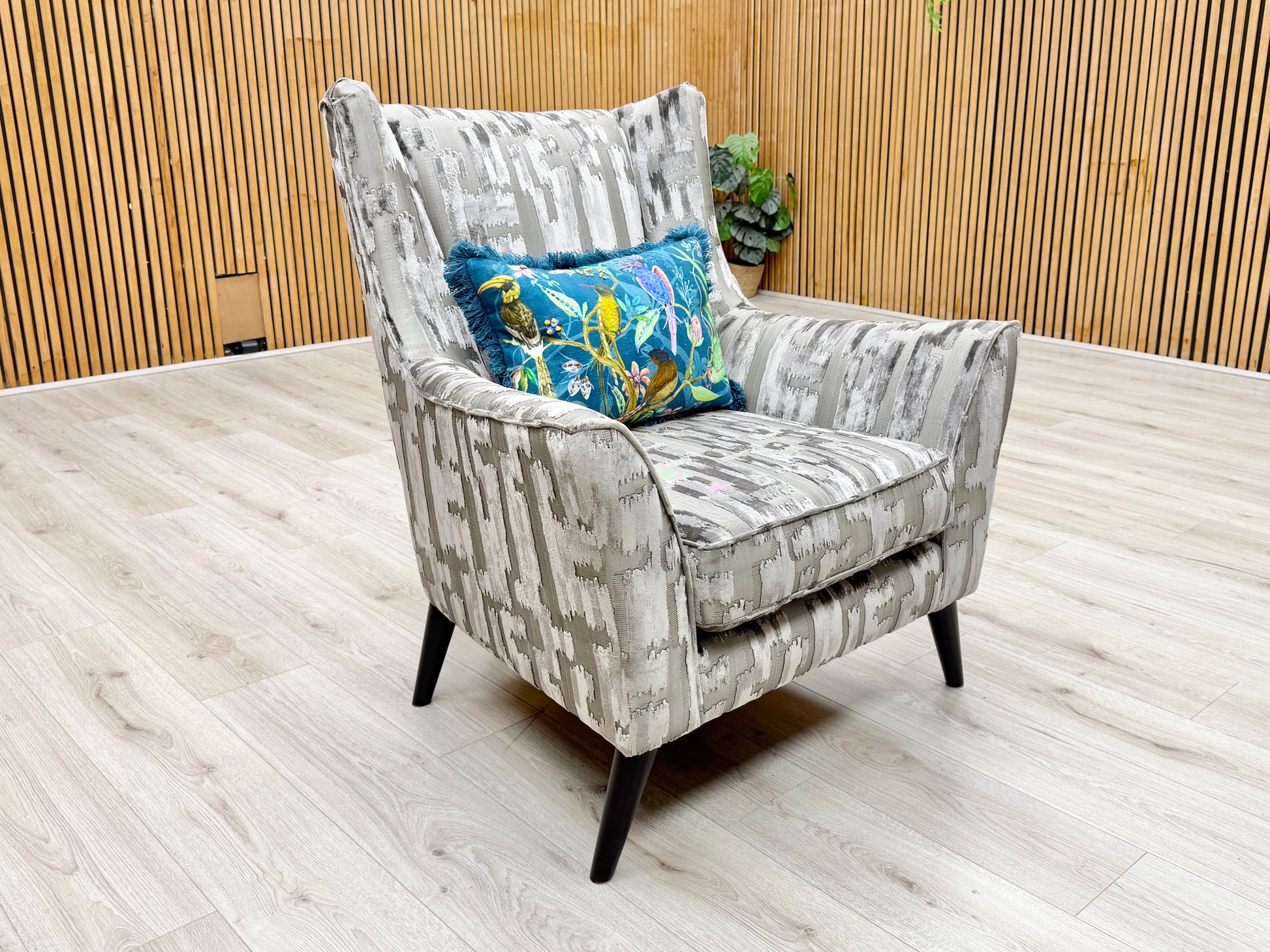 Lifestyle view of the ‘Allure’ wing chair, emphasizing the plump, fixed Encore foam seat cushion and the distinctive textural depth of the patterned fabric.