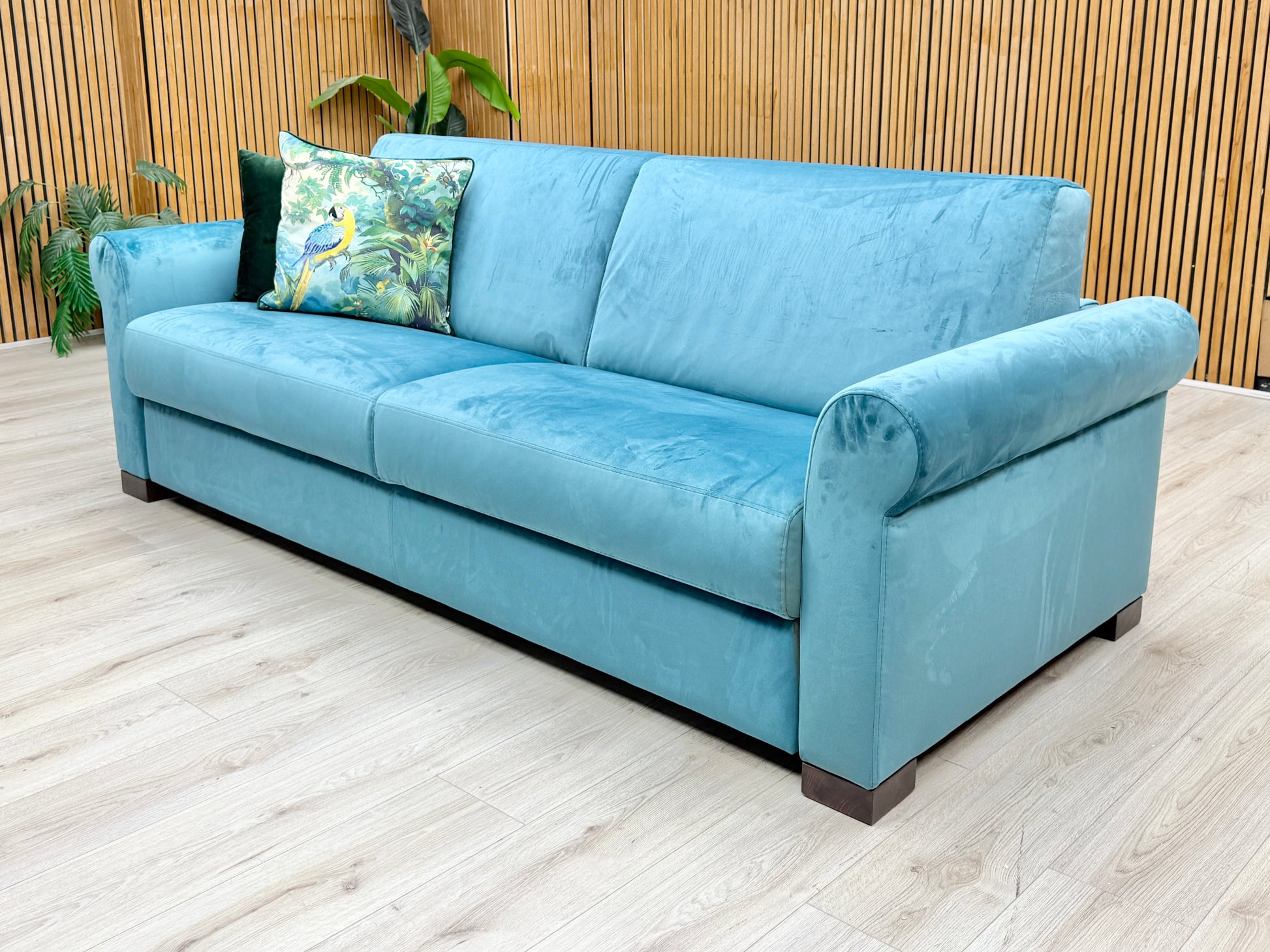 Lifestyle view of the ‘Alcova’ 3-seater sofa in teal velvet, emphasizing the rich, plush seating area and tactile warmth of the premium velvet fabric.