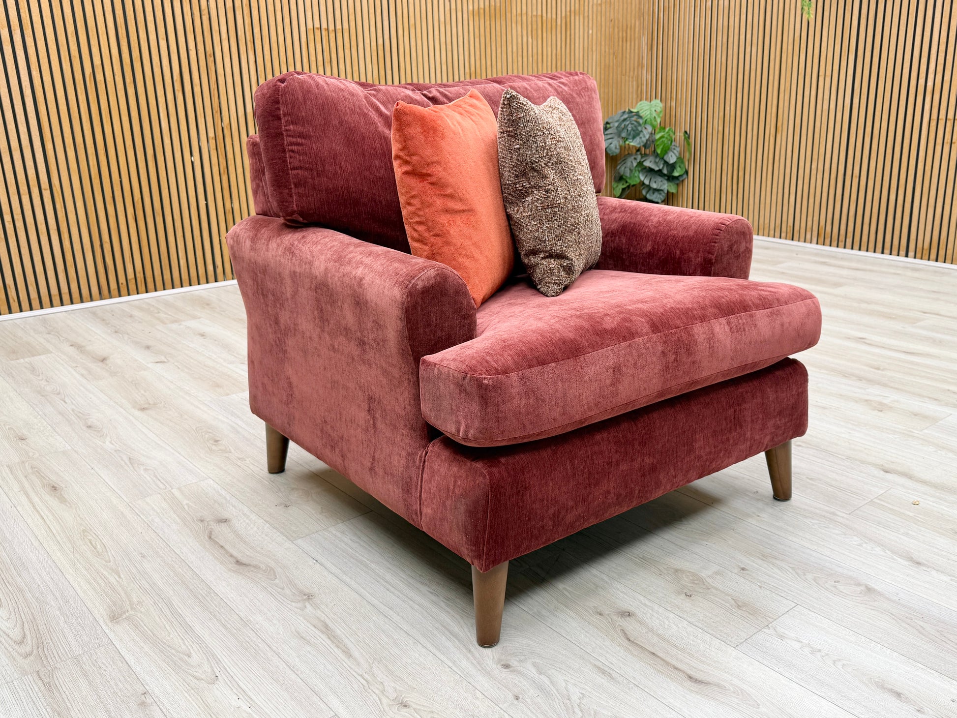Lifestyle view of the ‘Jackson’ fabric chair, emphasizing its wide, inviting seat profile and the rich, warm color of the Paprika Red upholstery.