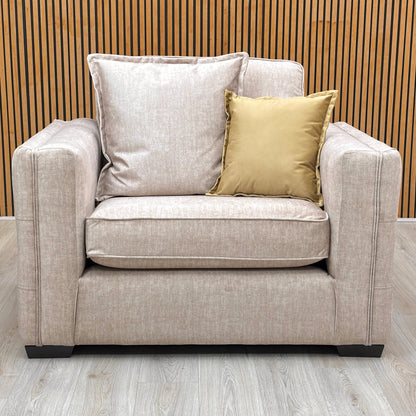 One of the Chelsea beige velvet snuggler chairs from the set against a slatted wooden wall