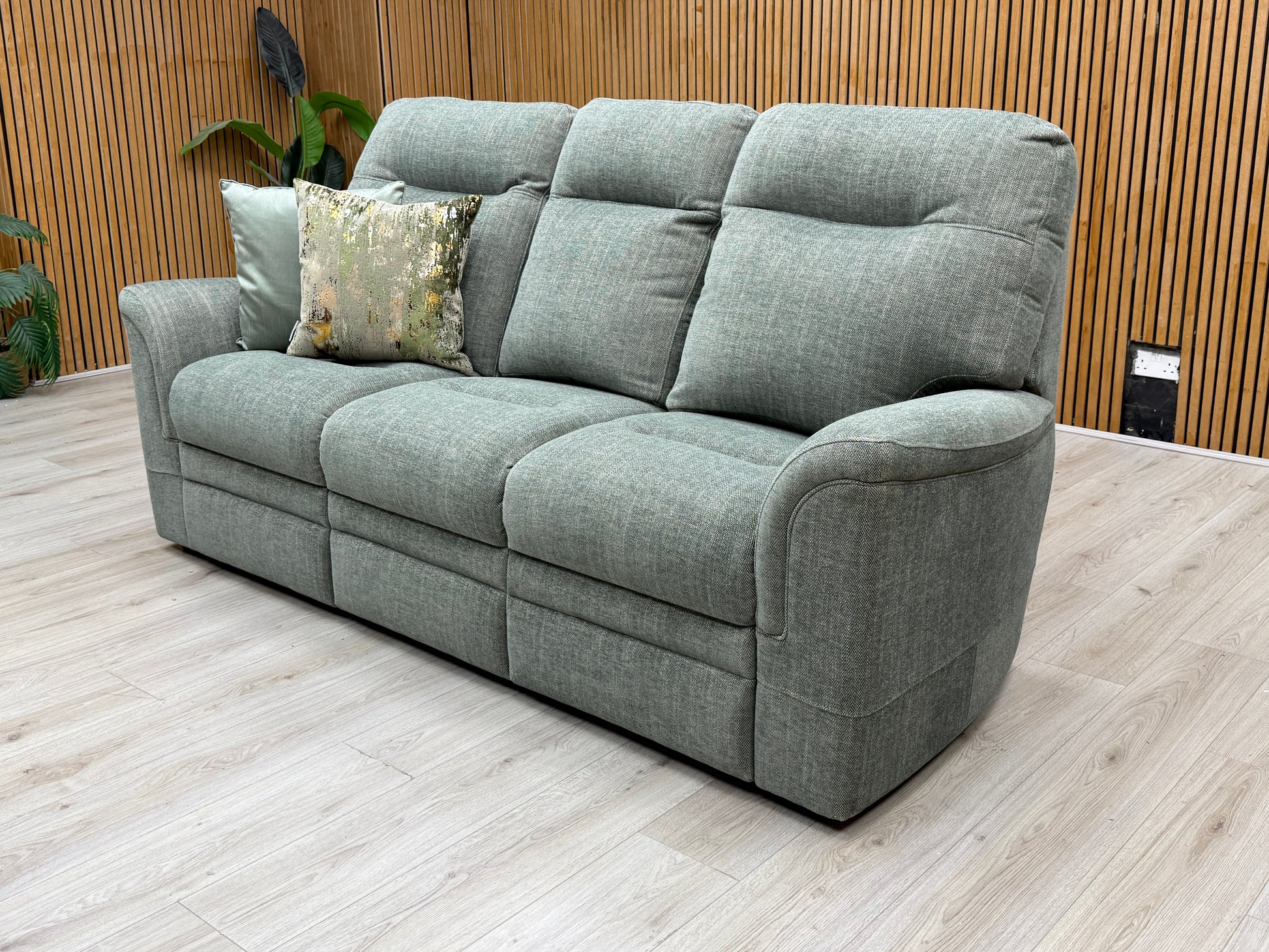 Lifestyle view of the ‘Hudson 23’ 3-seater sofa, emphasizing the premium textured weave of the conifer green fabric and the generous, deep seating area designed for relaxation.