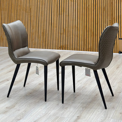Murcia antiqued olive green pair of dining chairs photographed on a light floor against a slatted wall