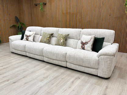Lifestyle view of three-quarter angled view of the Nova extra-large beige fabric power reclining couch, highlighting the clean stitching details and modern family living room design.