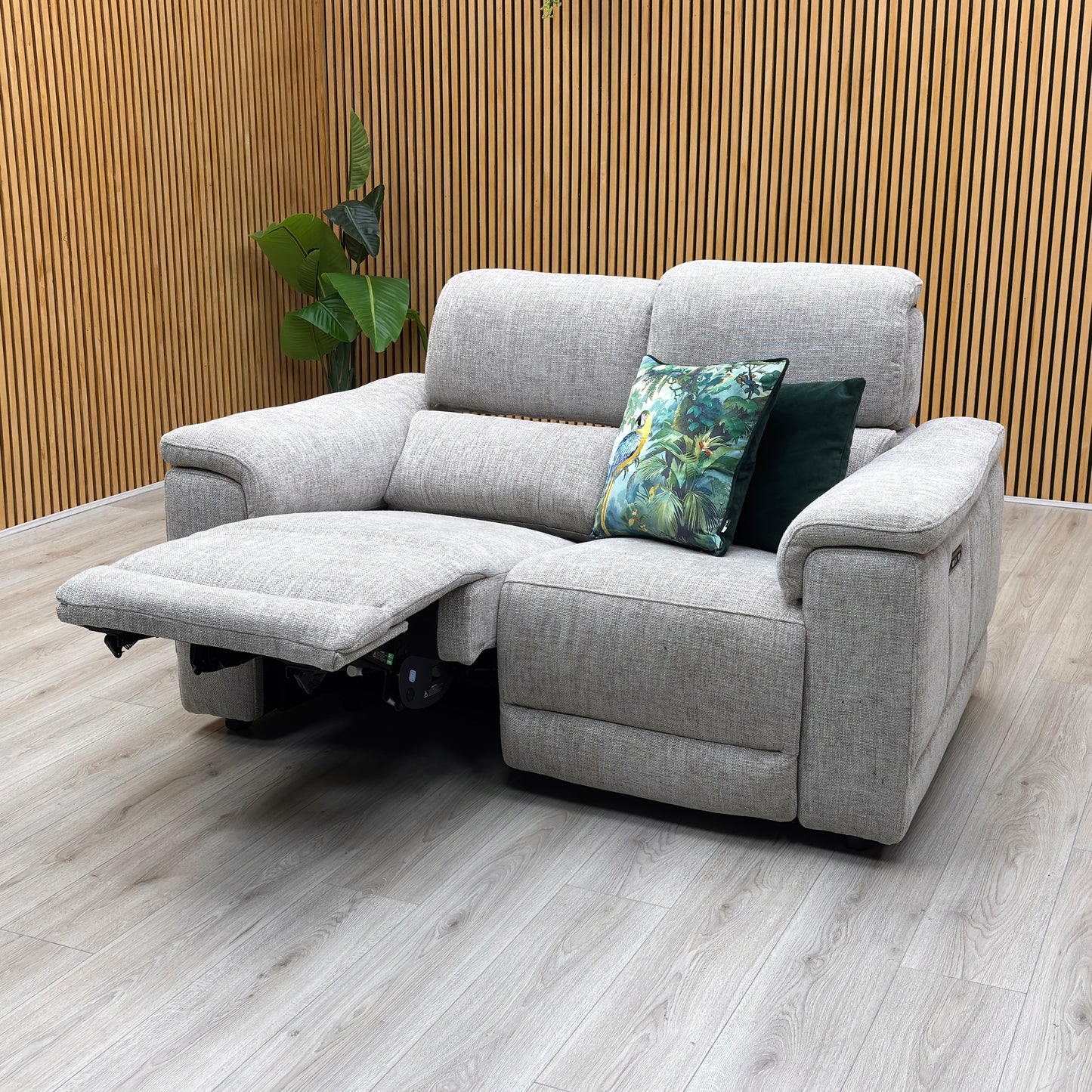 studio angle showing one seat fully extended in a relaxing lounging recline with the power headrest lifted and footrest extended.