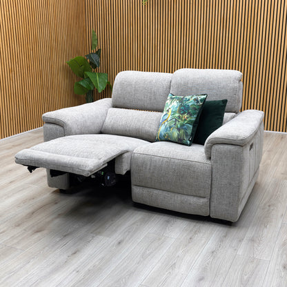 studio angle showing one seat fully extended in a relaxing lounging recline with the power headrest lifted and footrest extended.