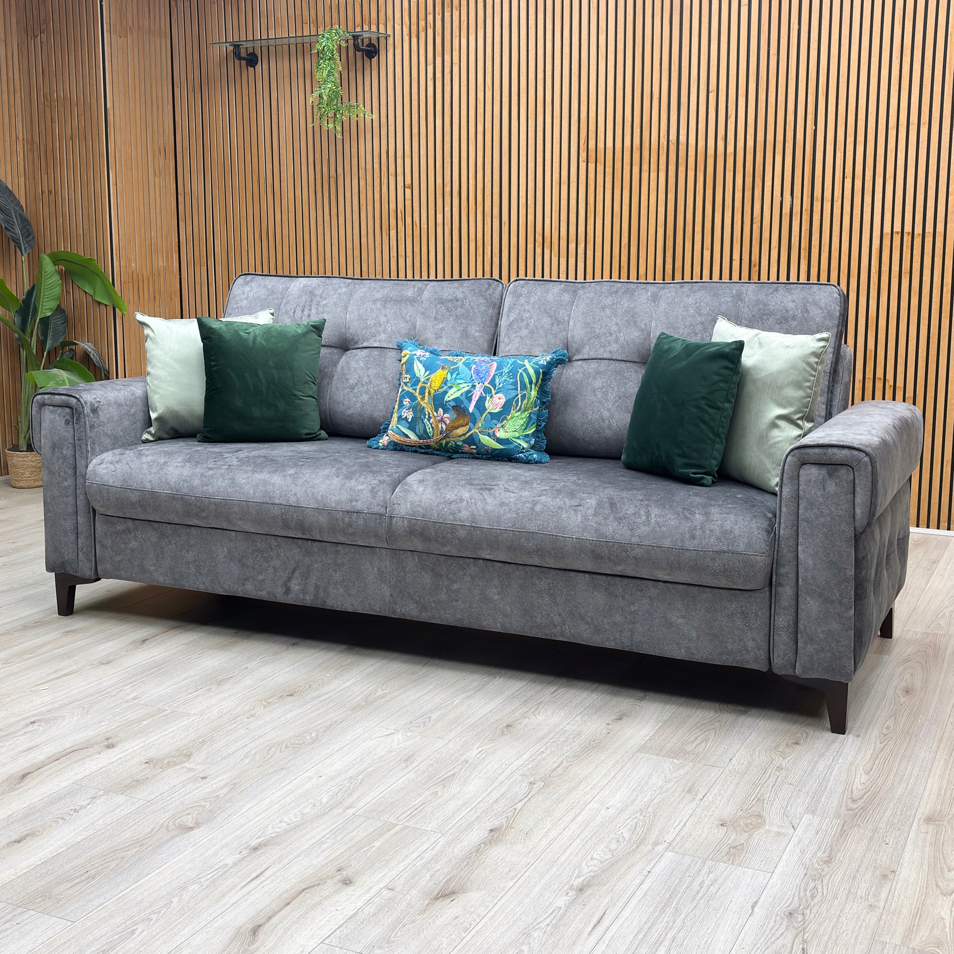 Lifestyle view three-quarter angled view of the Zoom dark grey fabric multi-functional sofa bed, highlighting the contemporary block silhouette and compact apartment-living design.