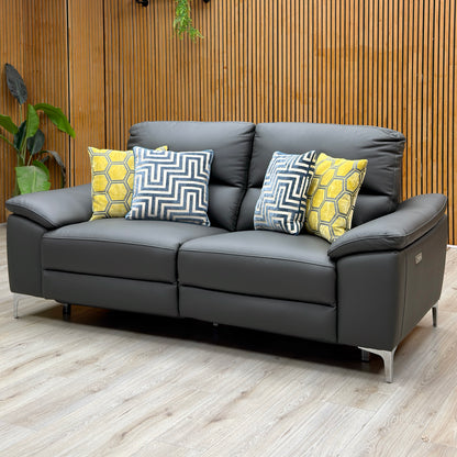 Pavillion charcoal grey leather 3 seater recliner sofa against a slatted wooden wall with yellow and navy cushions