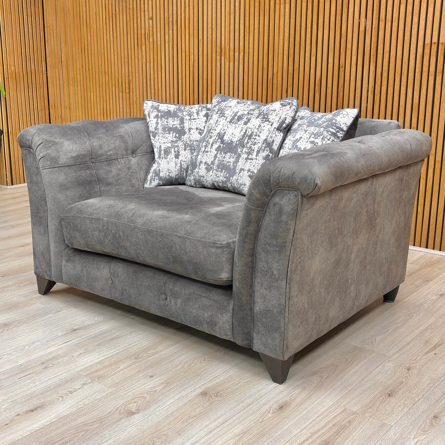Stylized lifestyle shot of the ‘Aura’ Kenzo love chair, highlighting the plush scatter back cushions and wide seating area.