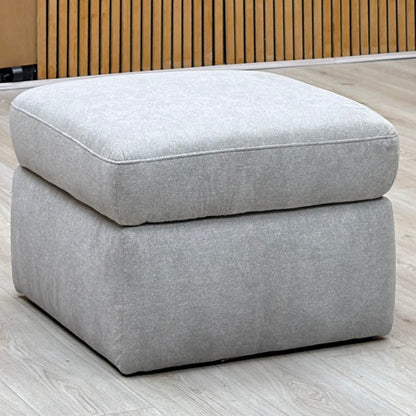 Berlin rosy light grey fabric storage footstool against a slatted wooden wall on a light oak floor