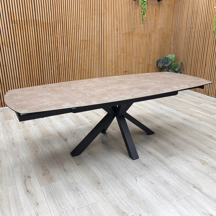 Raul argile ceramic top swivel extending dining table against a slatted wooden wall on a light oak floor