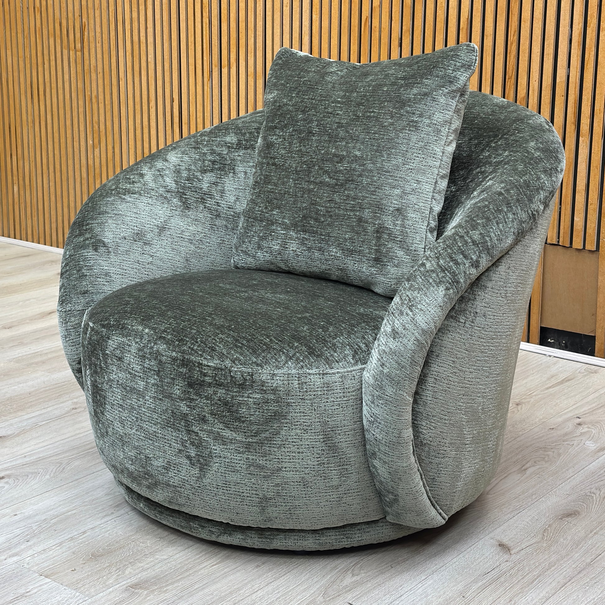 Stylized lifestyle shot of the ‘Jasper’ moss green chair, highlighting its rich moss green colour and textured chenille upholstery.