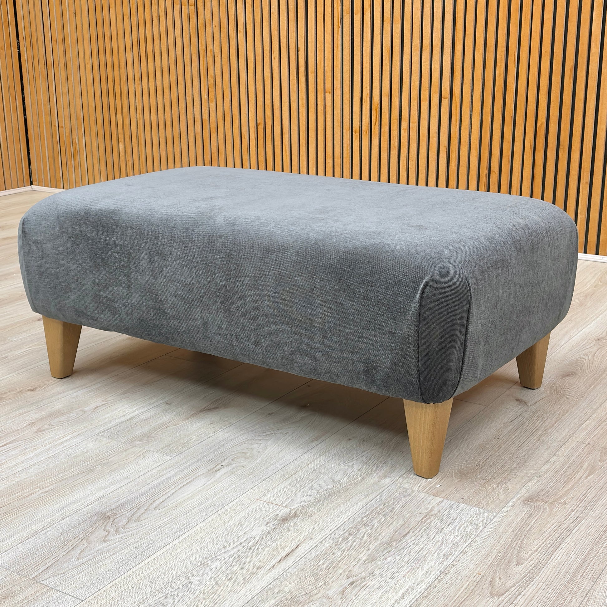 Stylized lifestyle shot of the ‘Soho’ Garda Carbon footstool highlighting the spacious, flat upholstered top surface.
