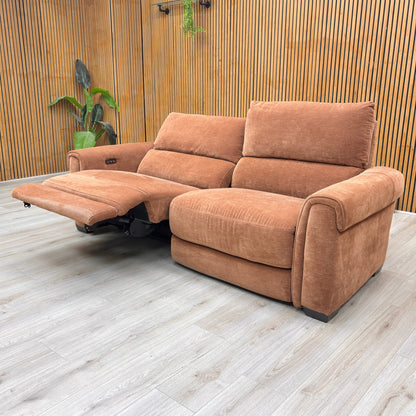 Stylized lifestyle shot of the caramel Nixon sofa in a modern, brightly lit living room.