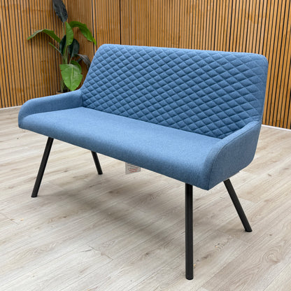 Rocket mineral blue fabric high back dining bench against a slatted wooden wall on a light oak floor