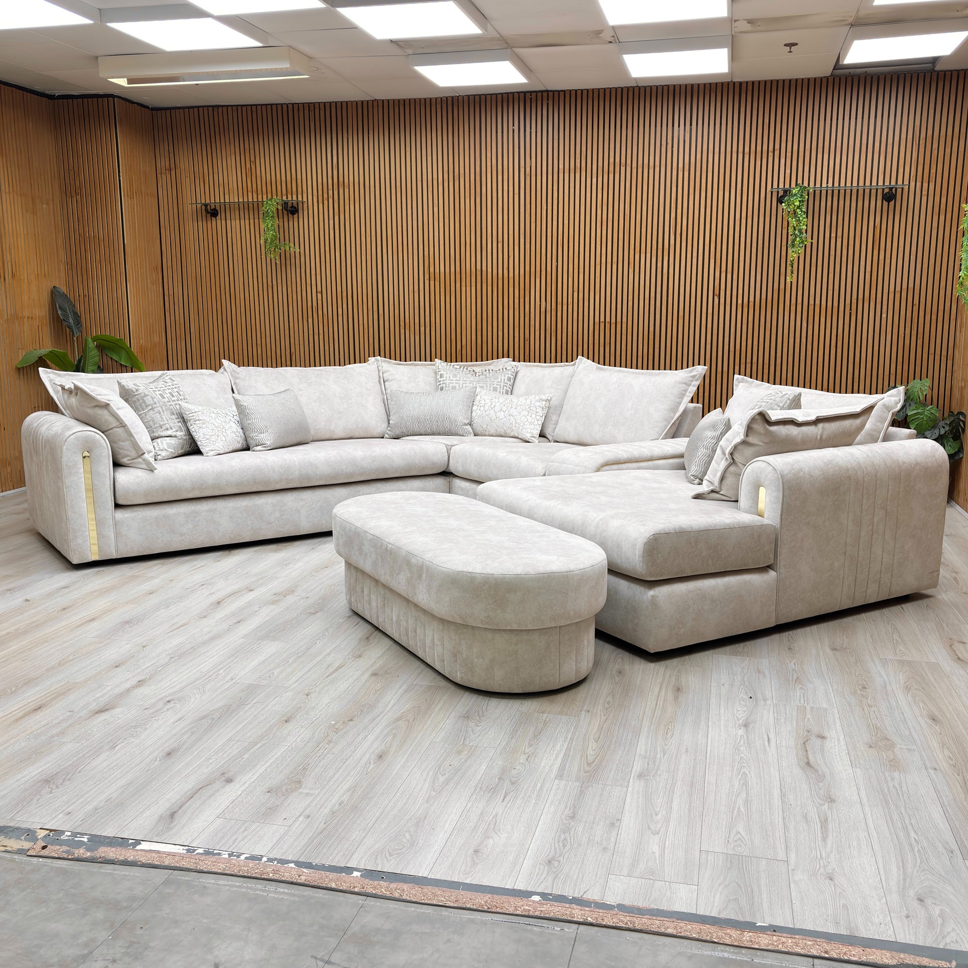 Stylized lifestyle shot of the Savoy corner sofa, highlighting the elegant marble-effect upholstery and gold base detailing.