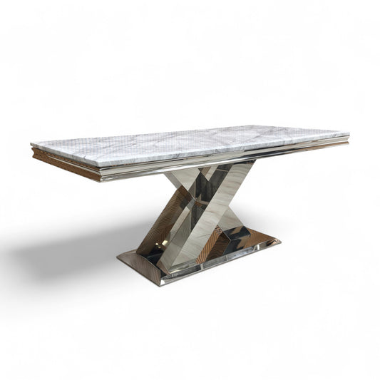 Full view of the 180cm 'Dolce' Fixed Dining Table, showcasing the light grey marble-effect ceramic top and the highly polished chrome X-shaped pedestal base in a contemporary setting.