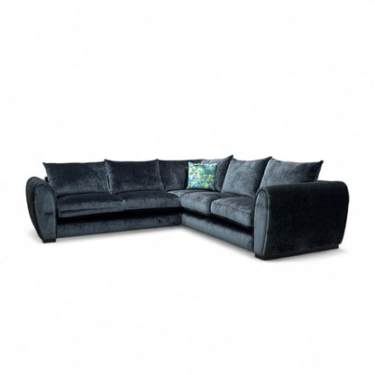 Maddison Dark Charcoal Grey Velvet 3-Seater Corner Sofa in a modern living room setting, showcasing its spacious L-shape design.