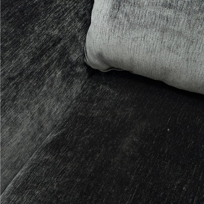 Close-up detail of the soft, dark charcoal grey velvet upholstery on the Maddison sofa.
