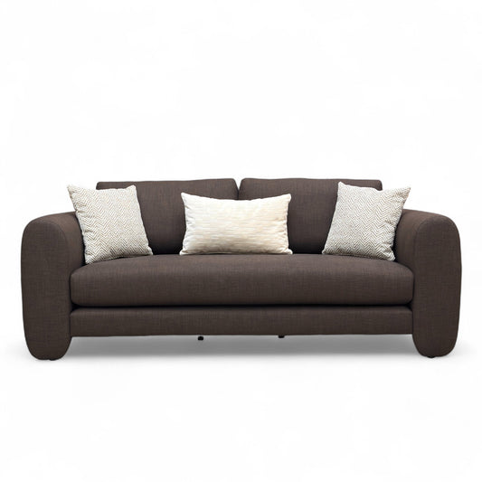Brown sofa with three cushions on a white background