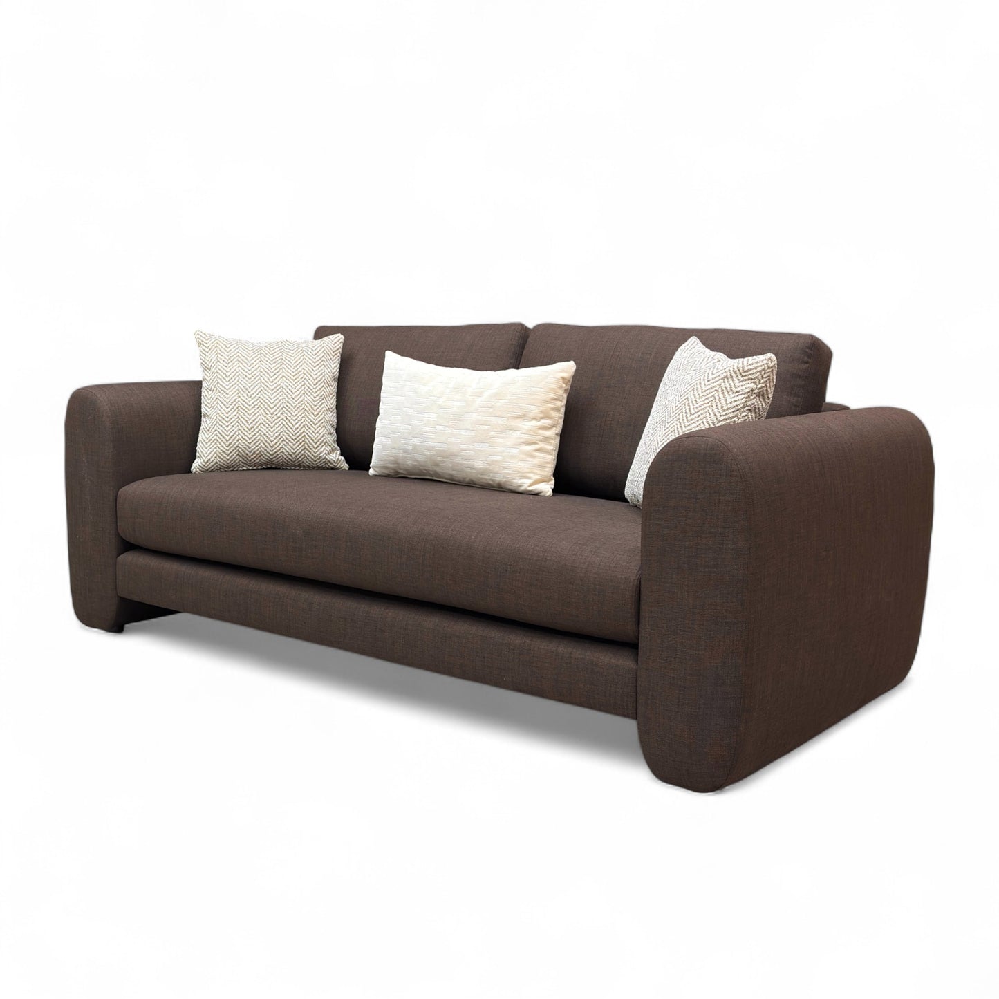 Brown sofa with three pillows on a white background