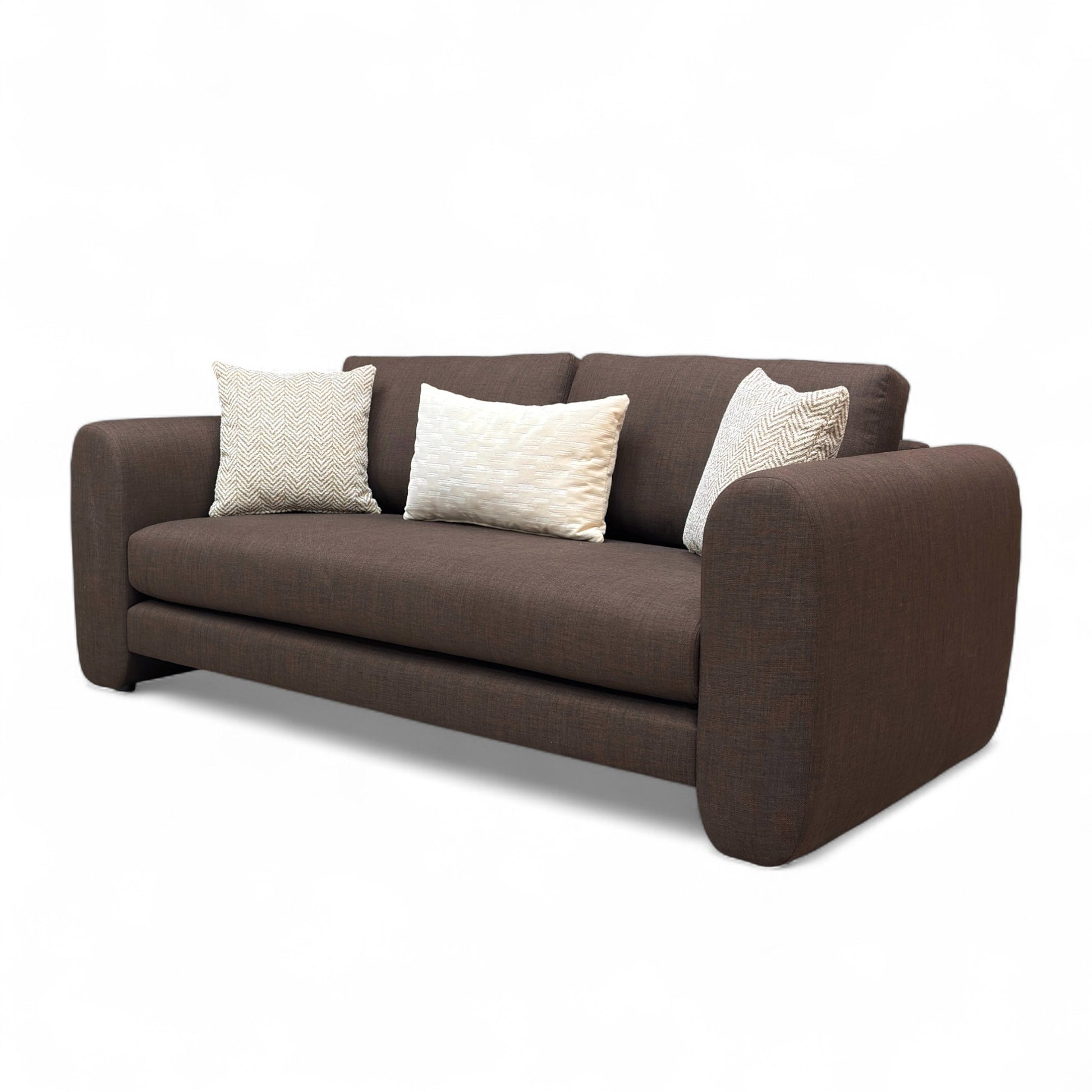 Brown sofa with three pillows on a white background