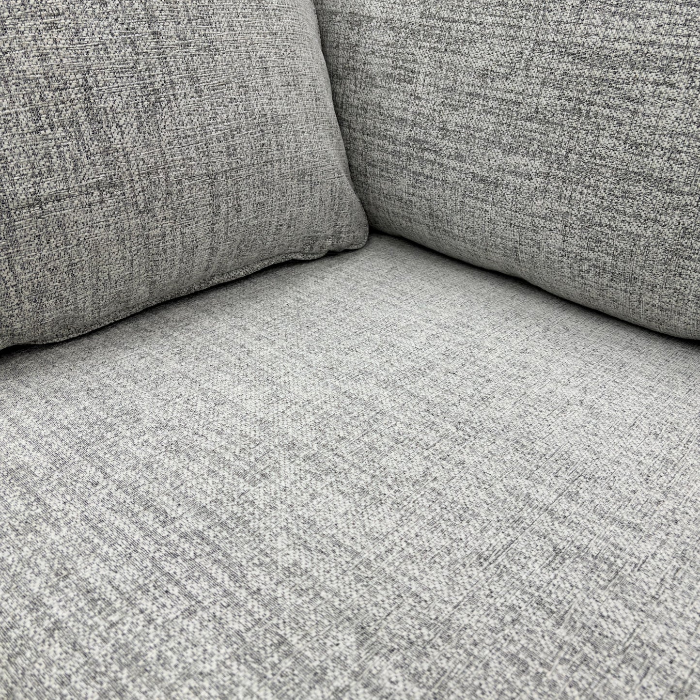 Close-up detail of the Sort Grey Woven Fabric upholstery, clearly showing the textured weave and neutral colour of the material.