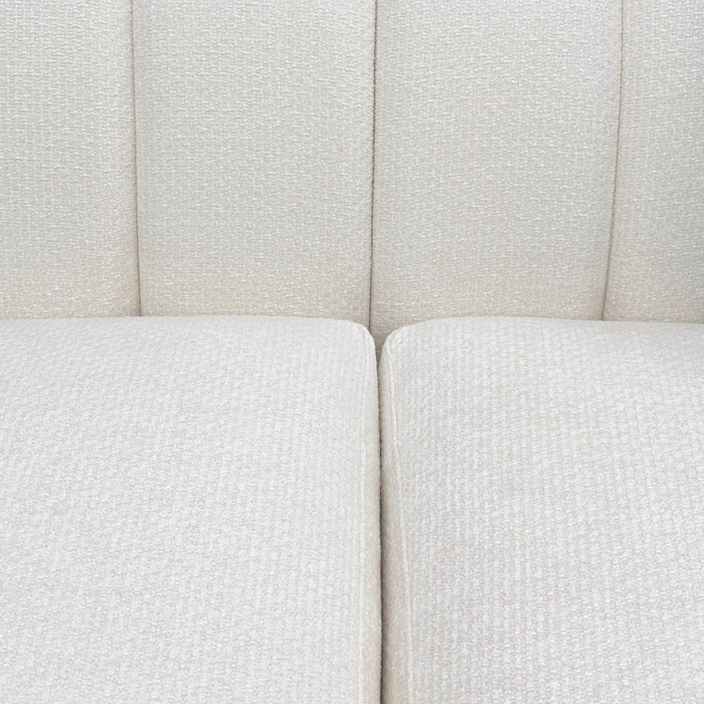 Close-up of a textured white sofa with a neutral color scheme.