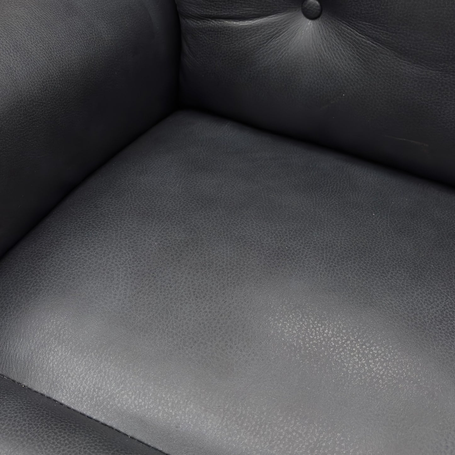 A close-up of a Black leather power recliner with footrest extended