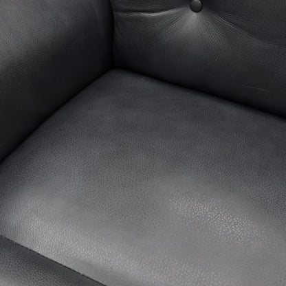 A close-up of a Black leather power recliner with footrest extended