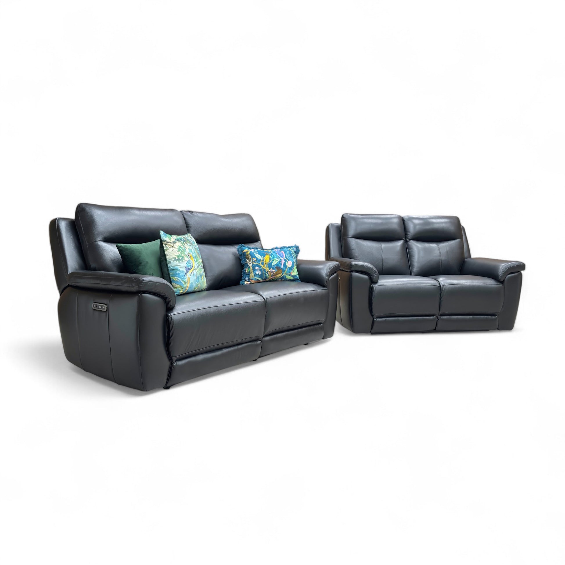 Black leather reclining sofa set with floral cushions on a white background