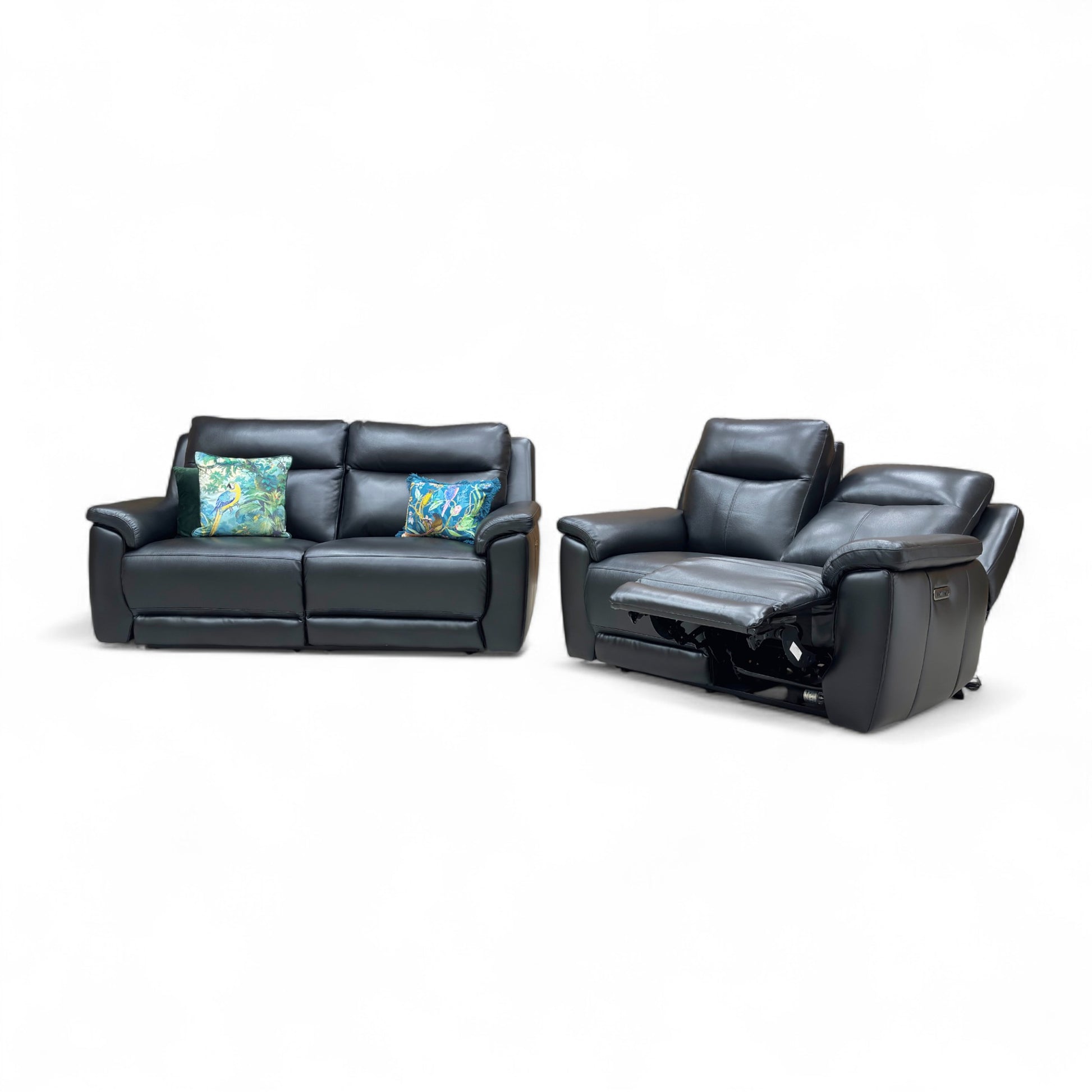 Black leather sofa and recliner with decorative pillows on a white background